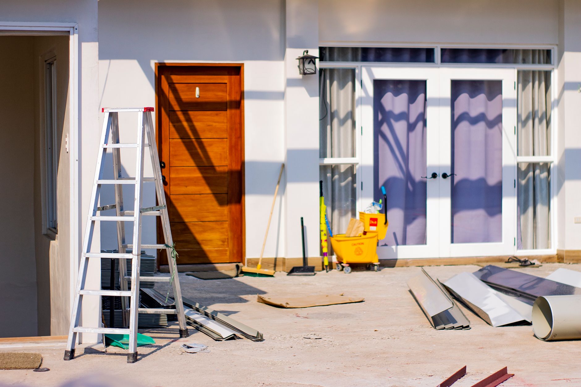A Southern California house under renovation with a contractor working on the exterior